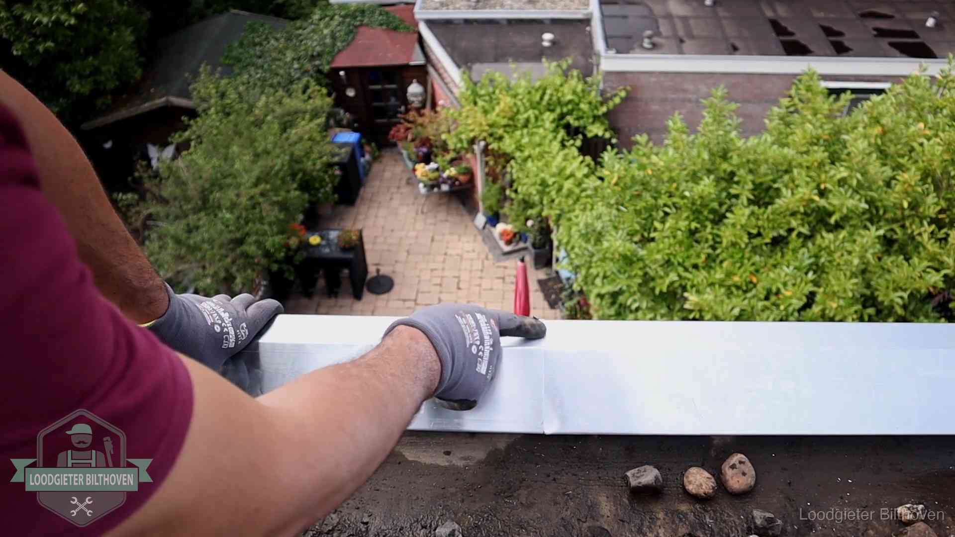 Daklekkage geregeld in Bilthoven Vakman plaatst een daktrim op de dakrand van een woning in Bilthoven