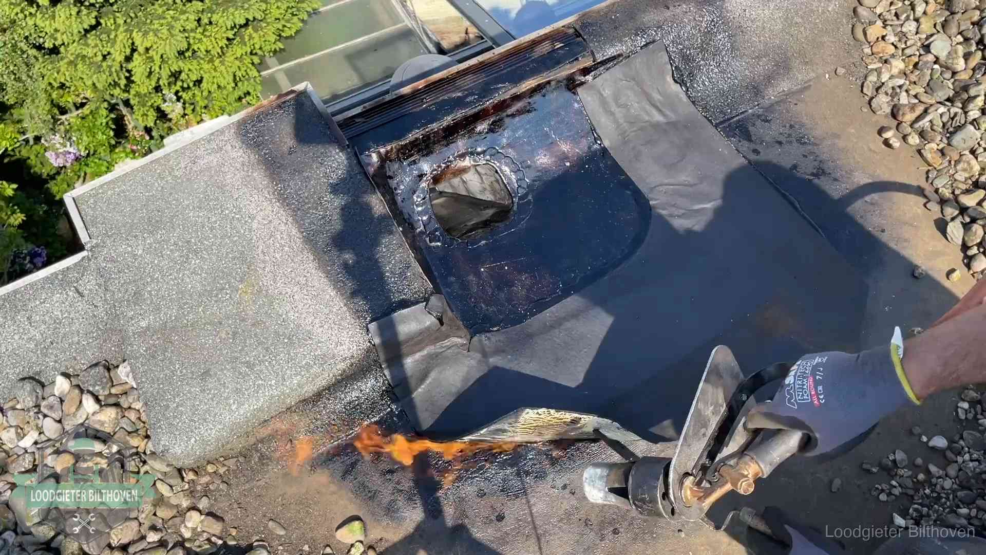 Daklekkage repareren in Bilthoven Dakdekker brandt bitumen rond een doorvoer tijdens een daklekkage-reparatie in Bilthoven