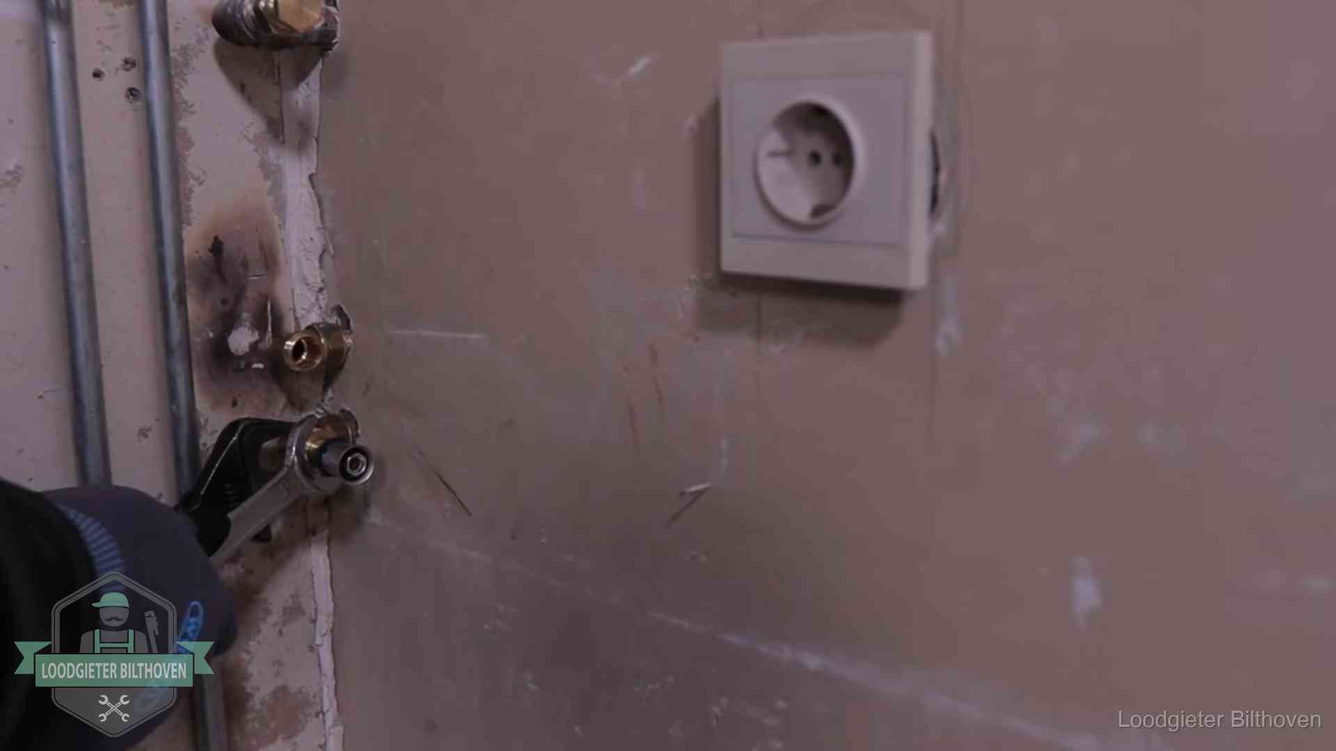 Monteur draait een perskoppeling vast op een leidingaansluiting in Bilthoven