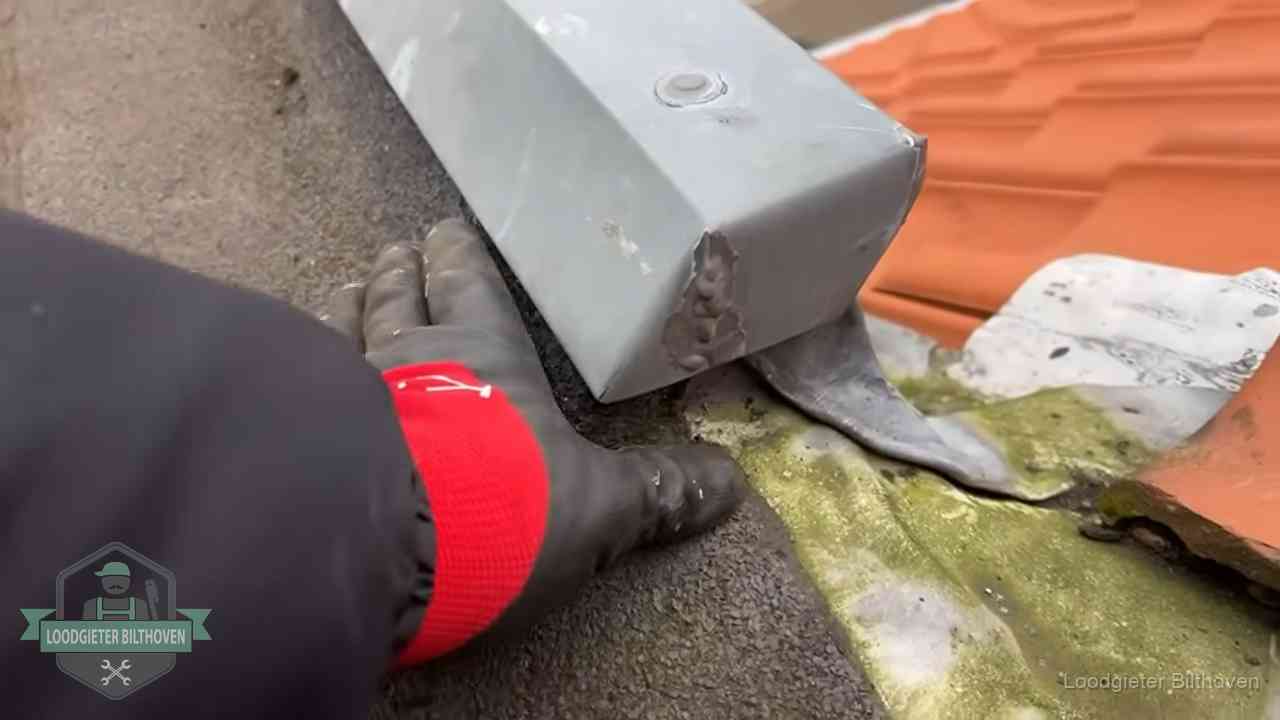 Hemelwaterafvoer en dakgoot controleren in Bilthoven Controle van een zinken hemelwaterafvoer met loodslab bij dakpannen in Bilthoven