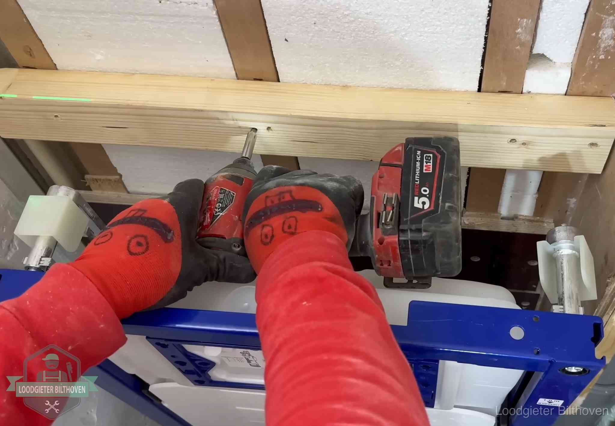 Monteur bevestigt een inbouwreservoir voor een hangend toilet in Bilthoven