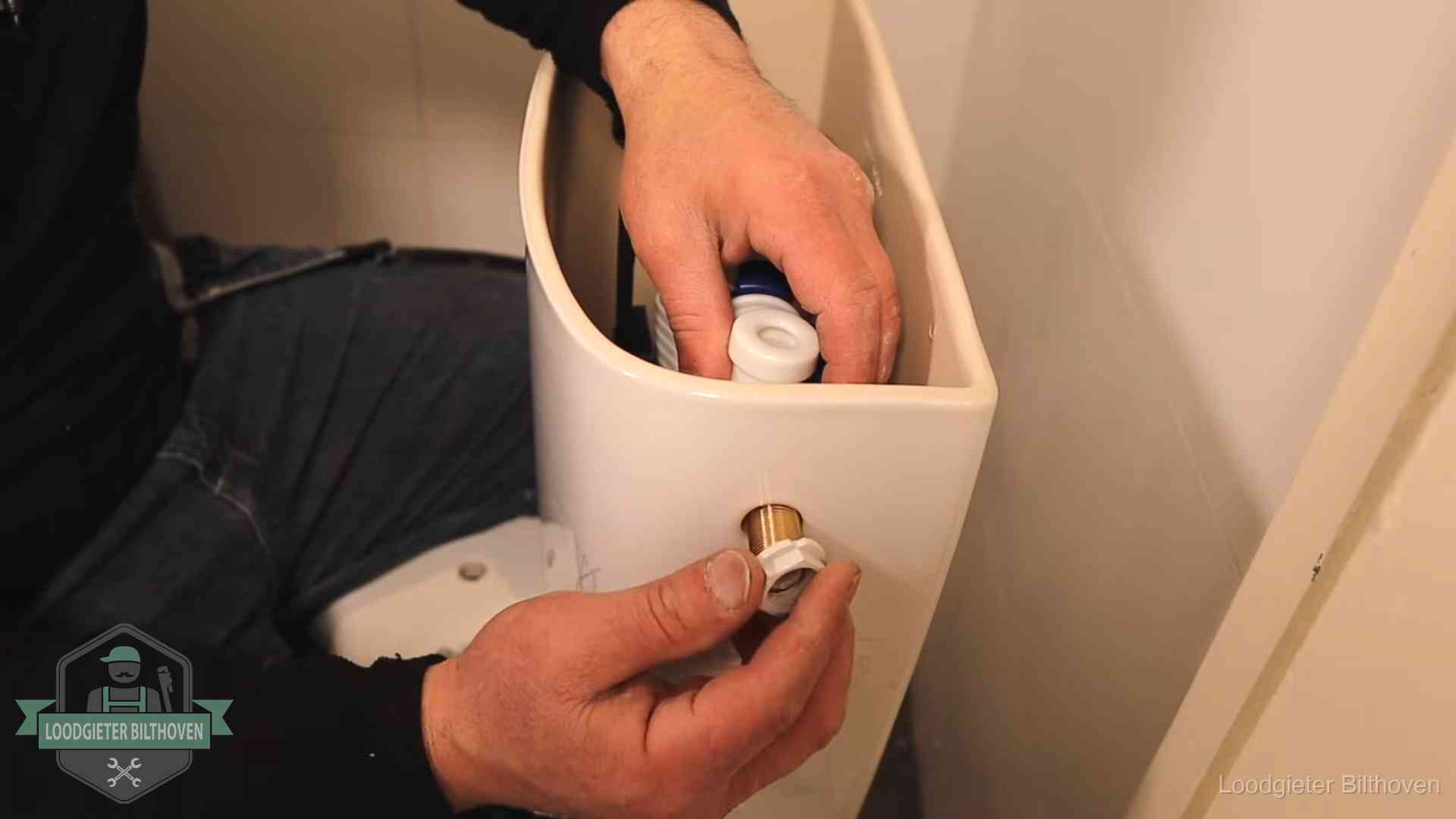 Loodgieter monteert de vlotterkraan van een stortbak bij een toilet in Bilthoven