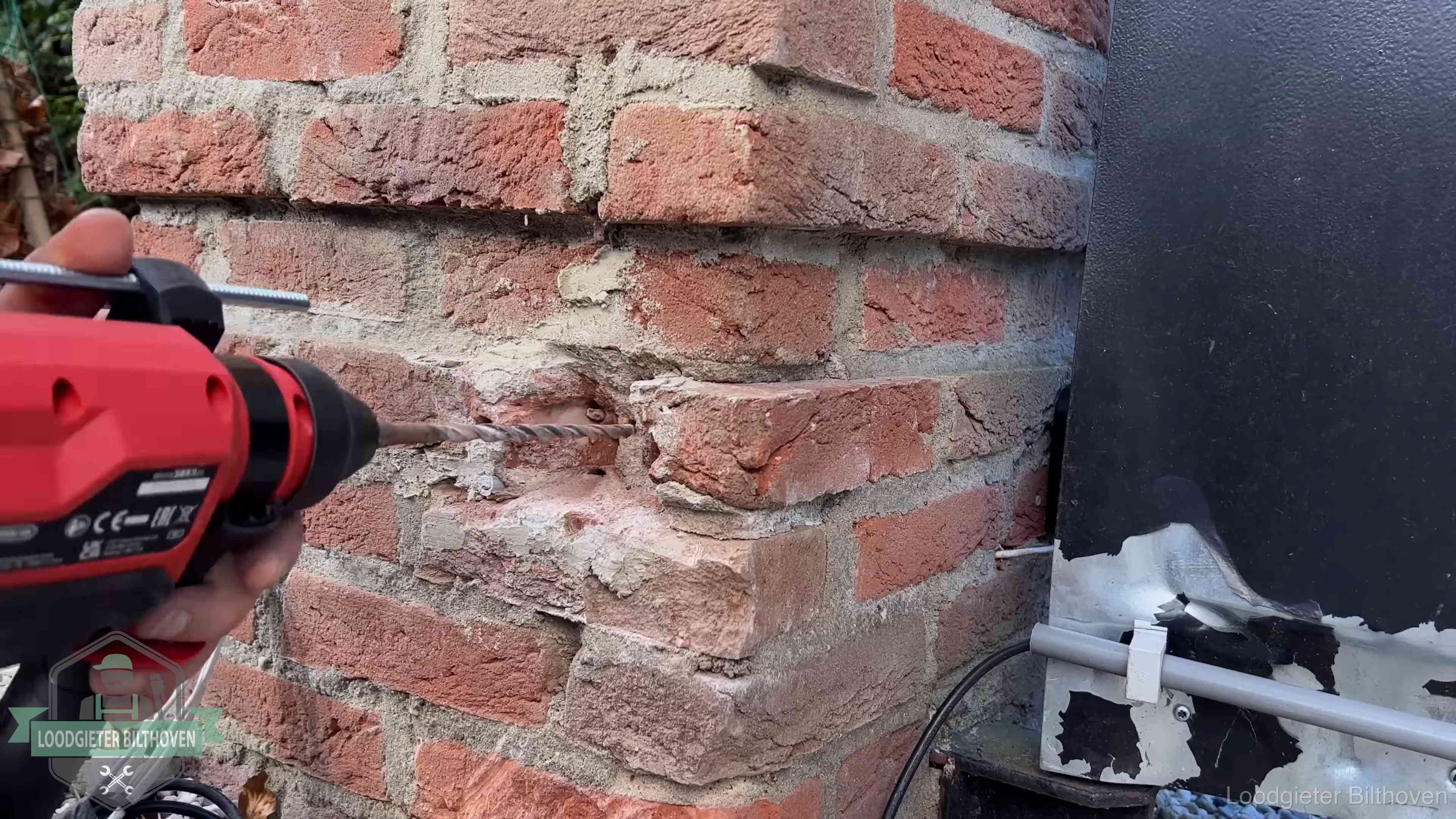Vakman boort in de buitenmuur van een woning in de regio Bilthoven