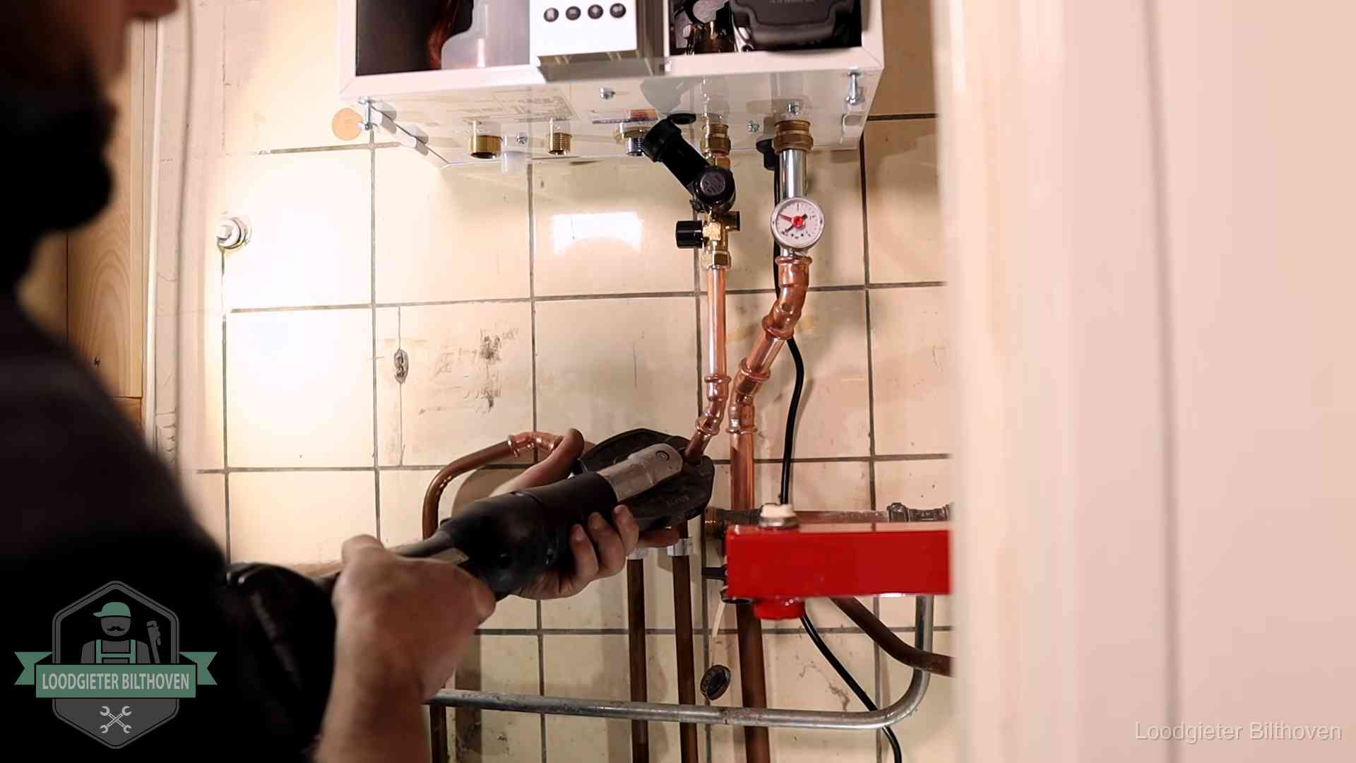 Cv-ketel onderhoud in Bilthoven Monteur werkt aan de leidingen onder een cv-ketel in Bilthoven
