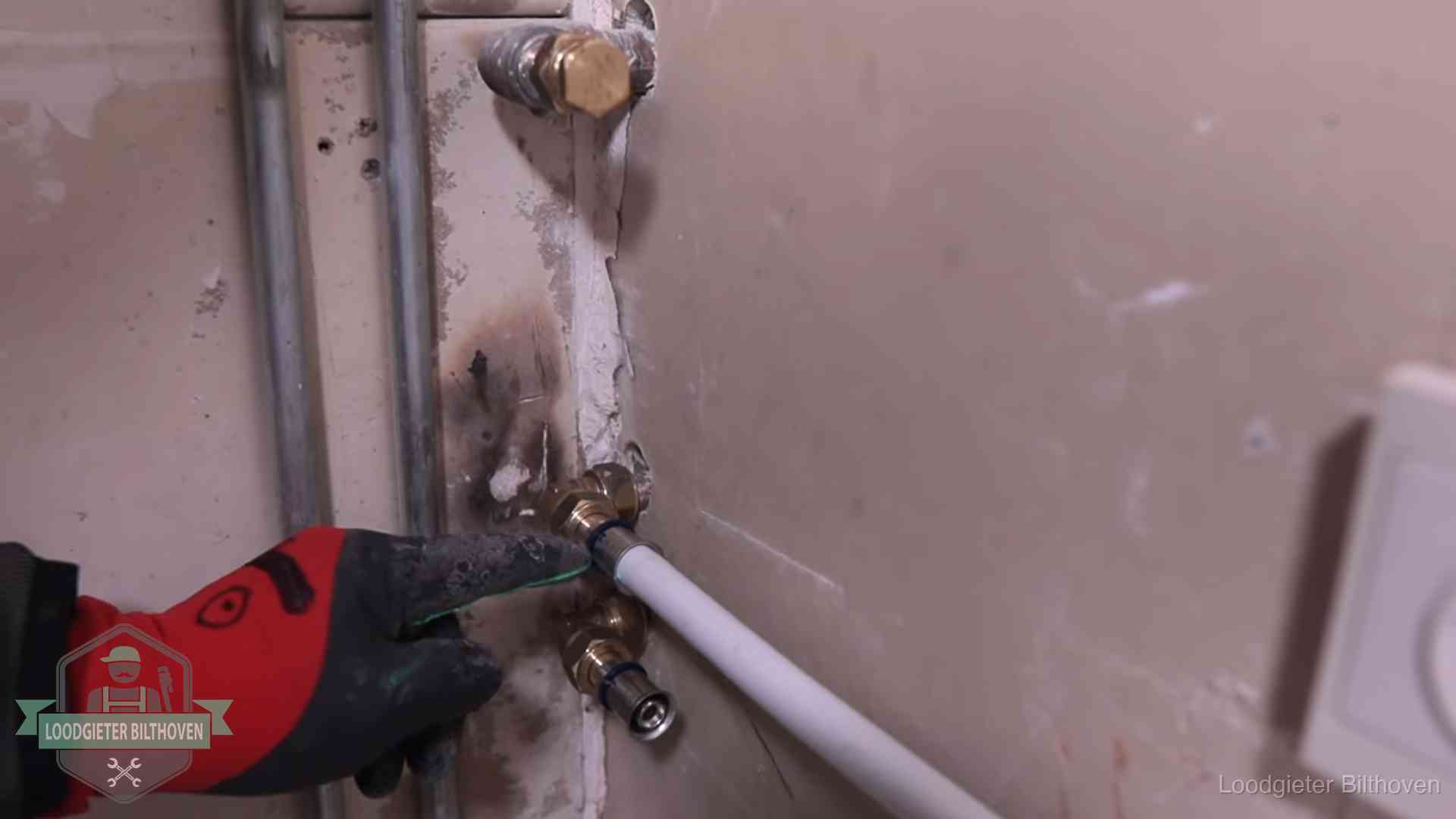 Loodgieter wijst de persfitting op nieuwe muuraansluitingen aan in een woning in Bilthoven