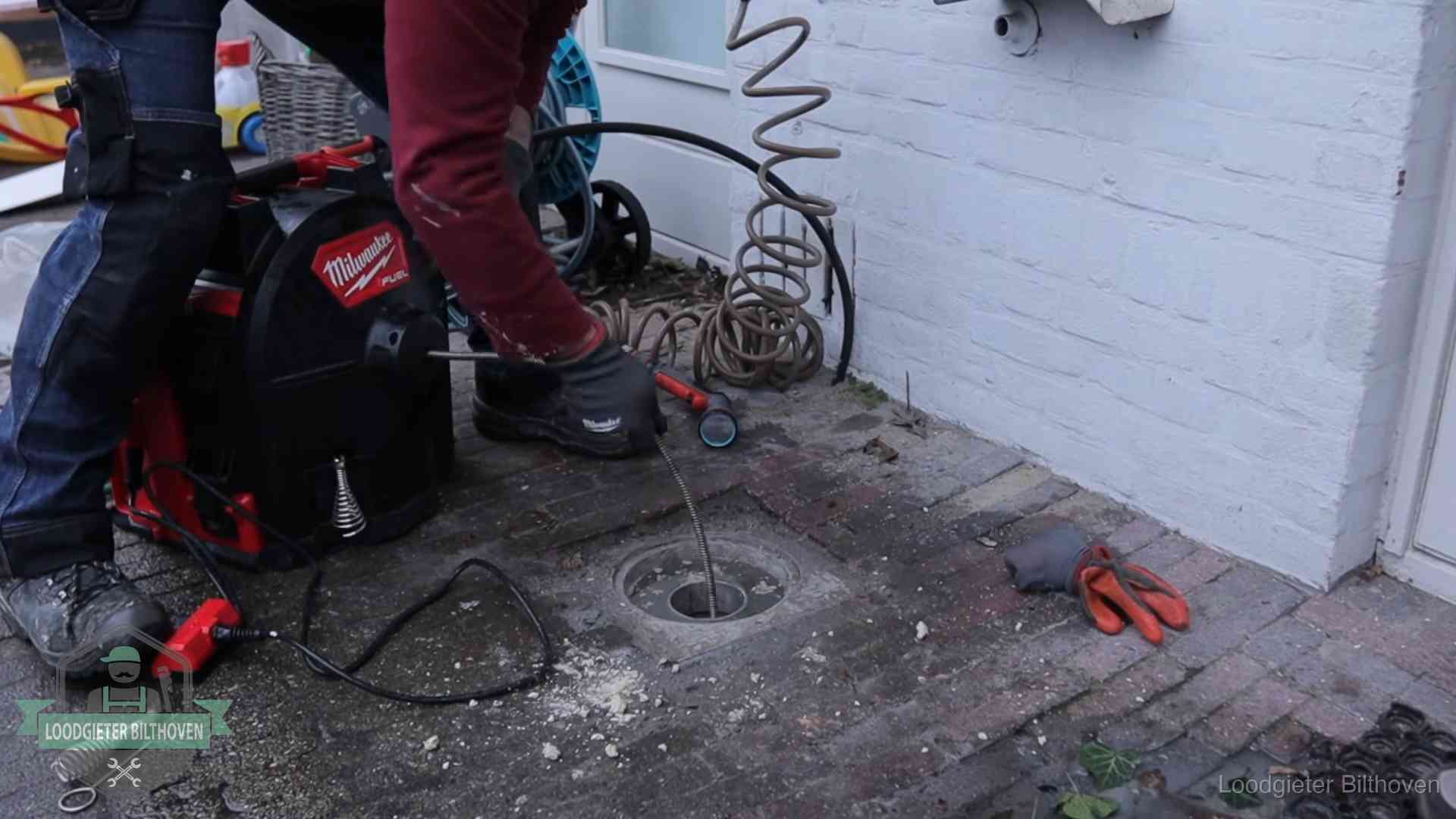 Prijs van een rioolontstopping in Bilthoven Spiraalmachine bij een ontstoppingsputje in de bestrating in Bilthoven