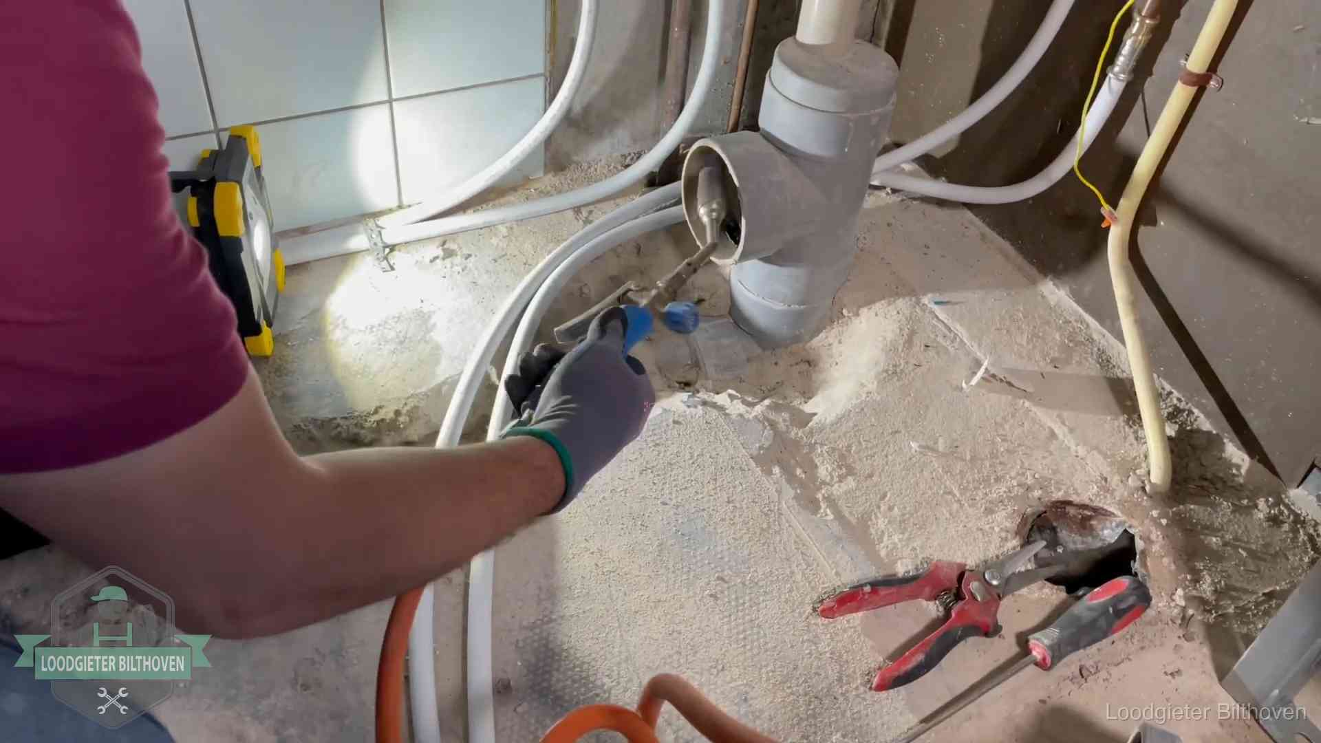 Loodgieter werkt aan leidingen bij een pvc-standleiding in een appartement in Bilthoven