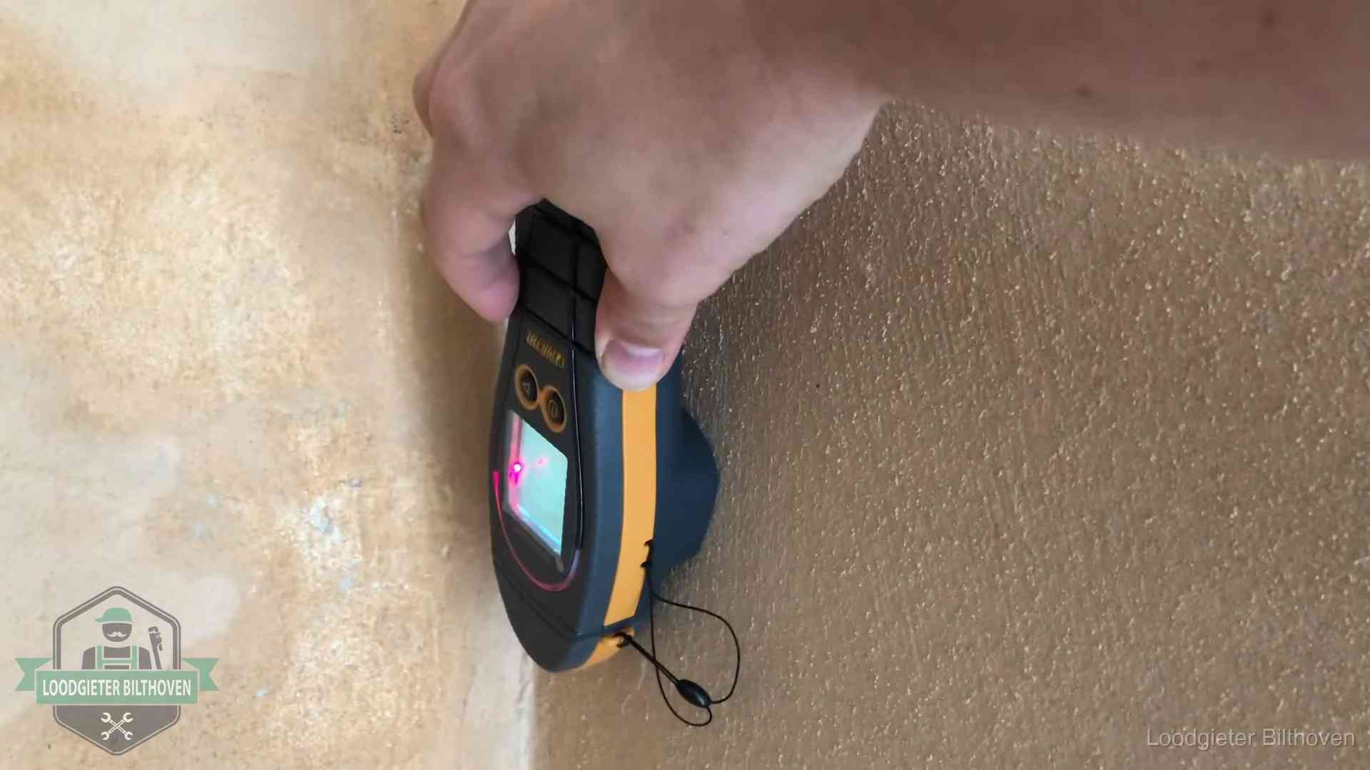 Daklekkage opsporen zonder hakwerk in Bilthoven Vochtmeter tegen een muur met vochtplekken tijdens het opsporen van een daklekkage in Bilthoven