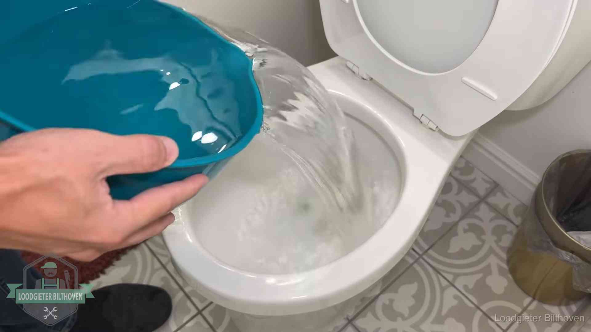 Warm water wordt voorzichtig in de wc-pot gegoten in Bilthoven