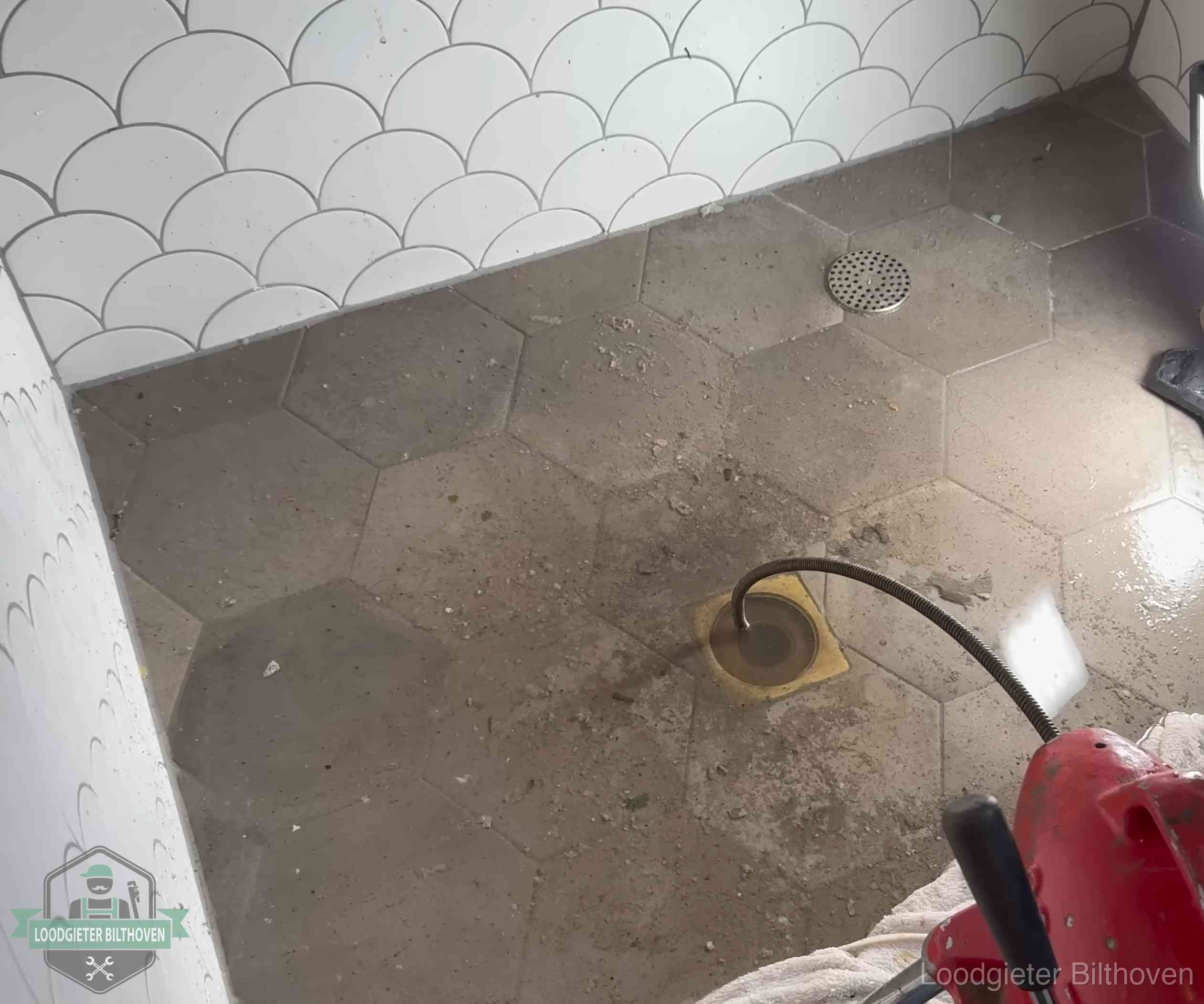 Vloerput met waterslot in een badkamer in Bilthoven, een bron van stank als het waterslot droogstaat