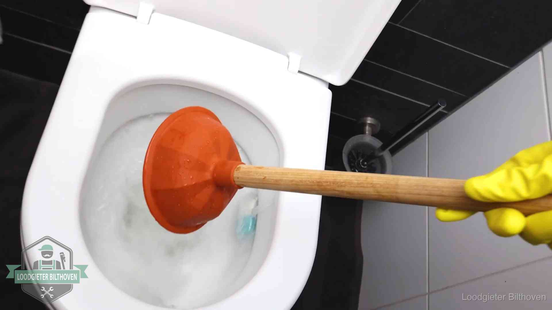 Plopper wordt in de wc-pot gedrukt bij het ontstoppen van een toilet in Bilthoven