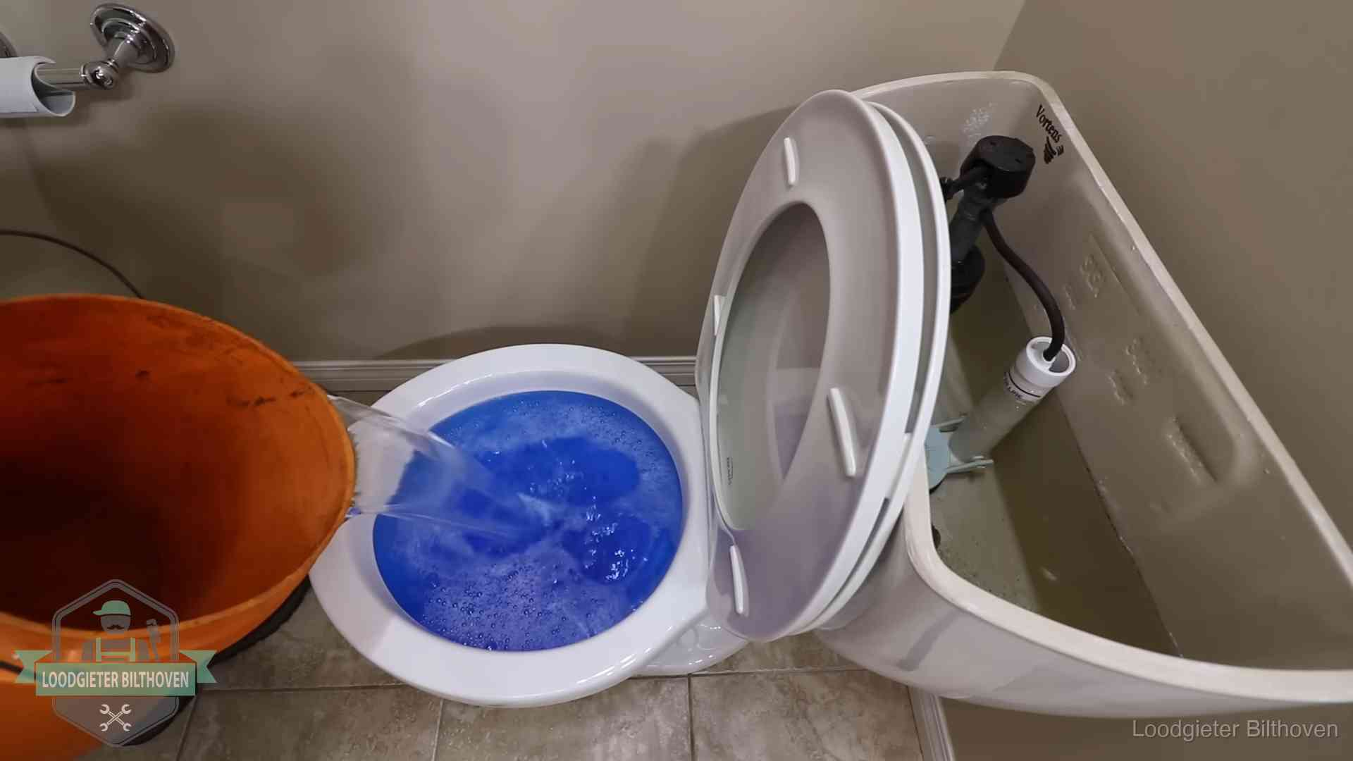 Water bij de wc-pot wordt met een emmer weggewerkt om schade te beperken in Bilthoven